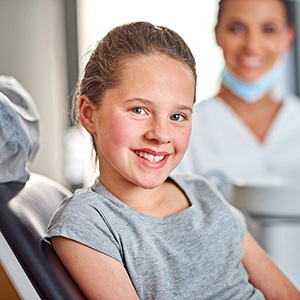 Young child resting on dental chair smiling