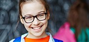 Young child with glasses smiling brightly