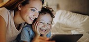 mother and child looking at tablet laughing