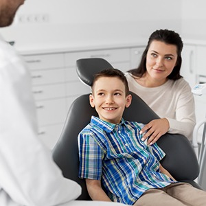 Child and parent talking to dentist