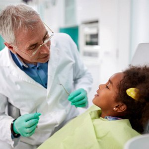 young girl talking to pediatric dentist 
