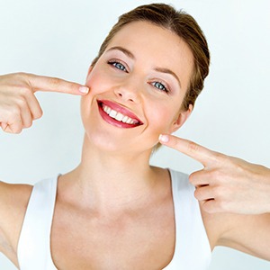 Woman pointing to her smile