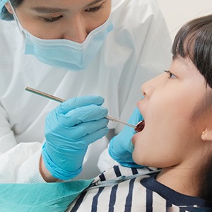 Young girl has her teeth examined by a dentist