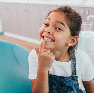 Smiling child pointing to their tooth