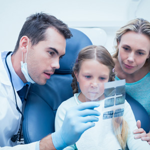 Dentist and a mother and her child discussing screenings 