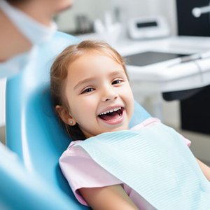 Happy young girl in dental treatment chair