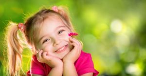 little girl hands on face smiling