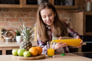 child pouring a glass of juice for themselves