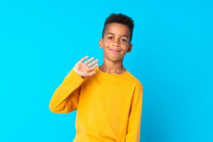 child smiling and waving