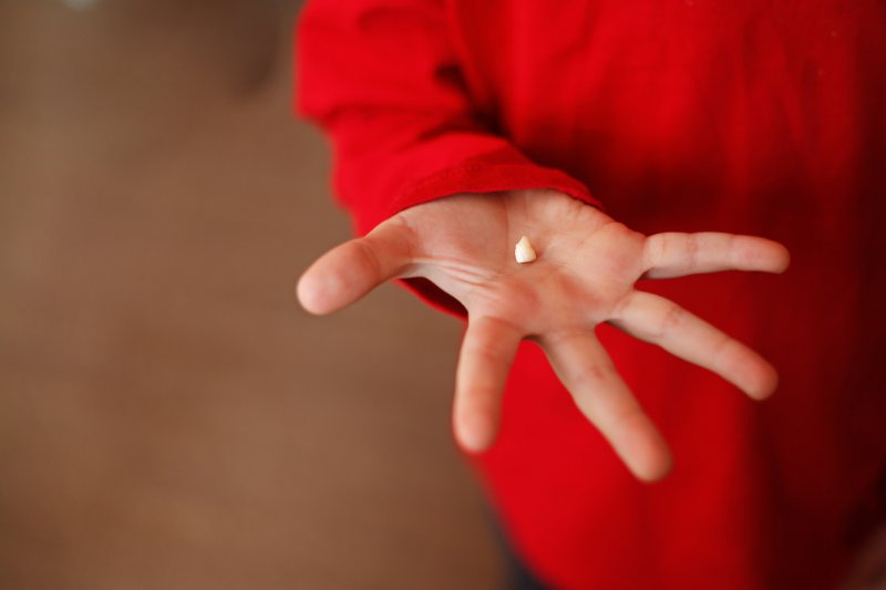 Closeup of baby tooth in child's hand