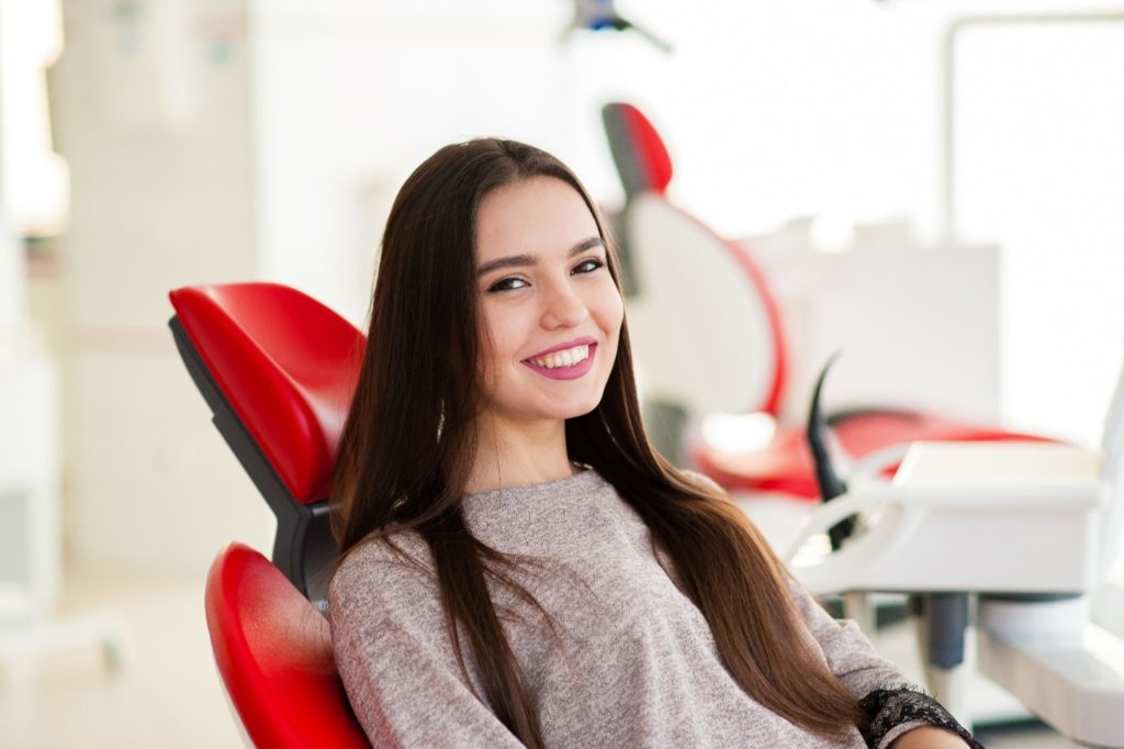 Teen girl smiling in dentist's treatment chair