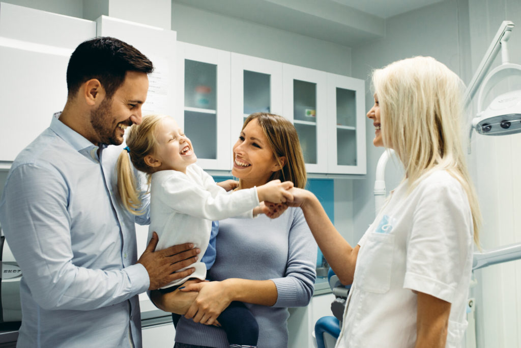 dentist talking to parents and child about children's tooth extractions in Naperville