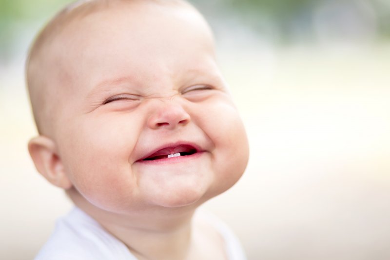 Smiling baby shows new teeth