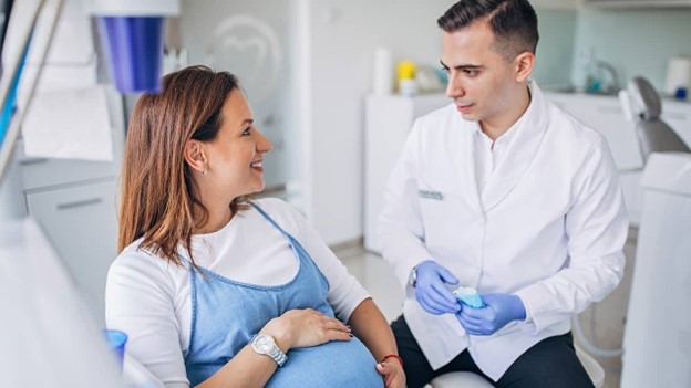 pregnant person speaking to dentist 